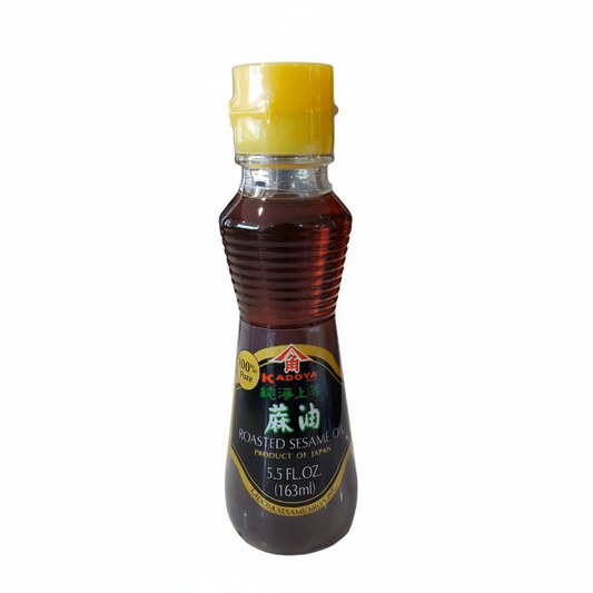 Bottle of roasted sesame oil with a yellow cap on a white background