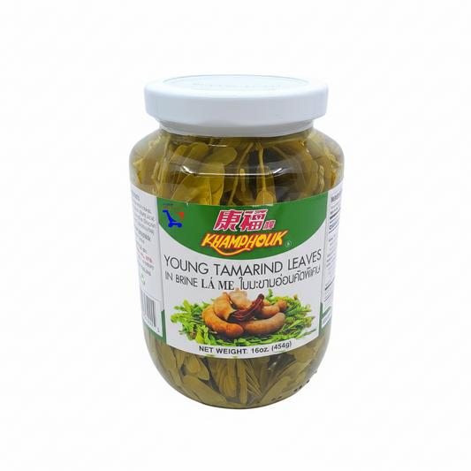 Jar of young tamarind leaves with a white lid on a white background, featuring the Kamyouk brand.